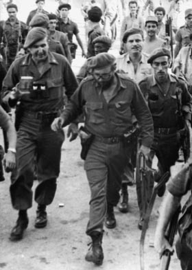 El Comandante en Jefe, acompañado por Fernández, el Comandante Flavio Bravo (detrás, vestido de miliciano), y otros compañeros.