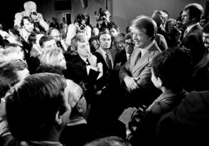 El presidente Carter, a la derecha, es rodeado por periodistas en Washington después de una conferencia de prensa en la que anunció la eliminación de la prohibición de viajar a Cuba, Vietnam, Corea del Norte y Camboya. Carter trató de normalizar las relaciones con Cuba poco después de tomar posesión en 1977.